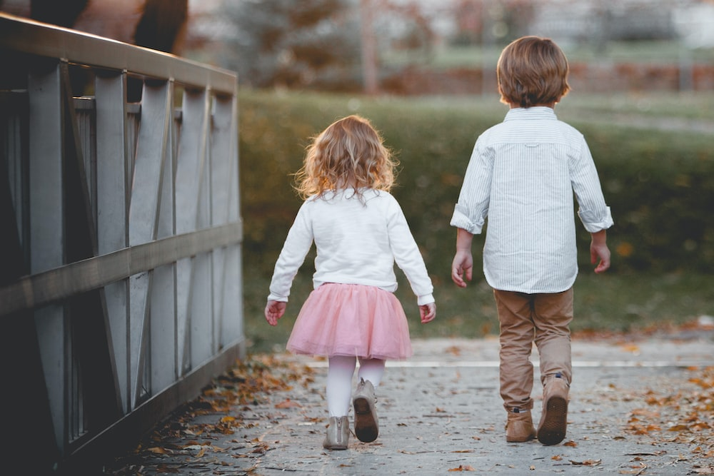 Two kids walking in a park