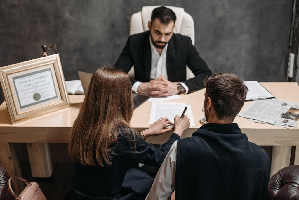 An attorney and an engaged couple finalizing prenuptial agreement