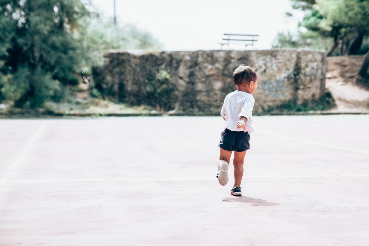 A kid running on a pavement