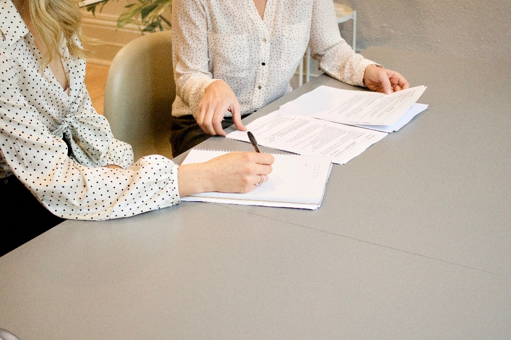 Two women reviewing asset documents for prenup considerations.
