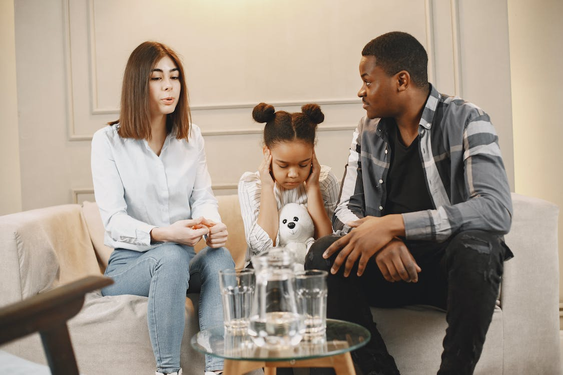 Daughter covering her ears while parents argue