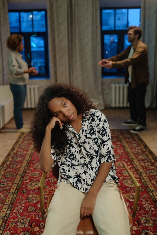 Young girl visibly stressed while her parents argue in the background.