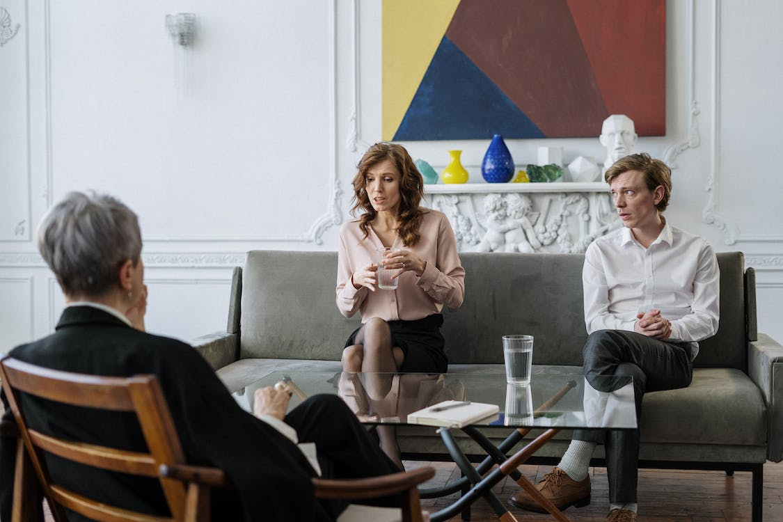 Therapist attentively listening to a couple discuss their issues.