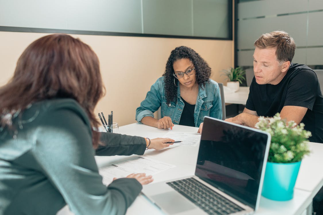 Couple and lawyer going through asset protection paperwork in the office