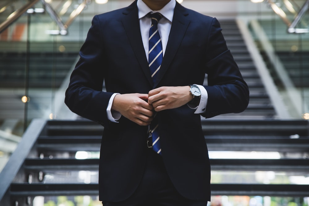 a person buttoning their suit