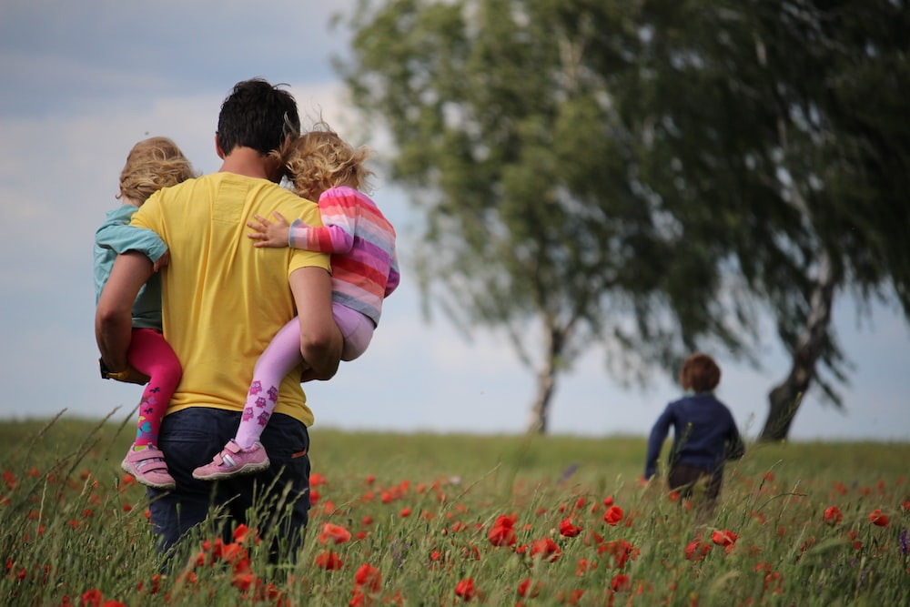 A father with his children in a field of flowers