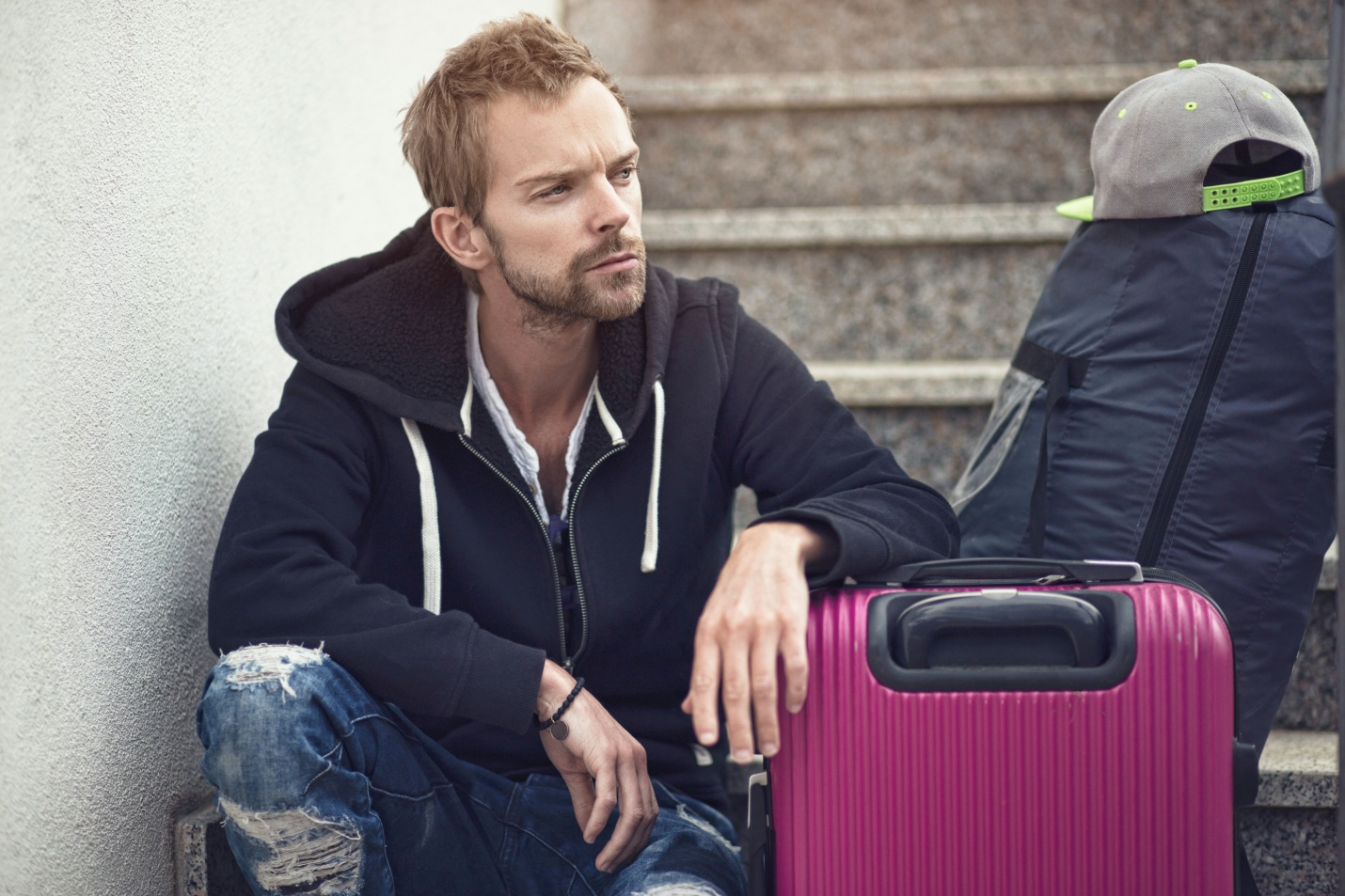 A man sitting on stairs with his luggage