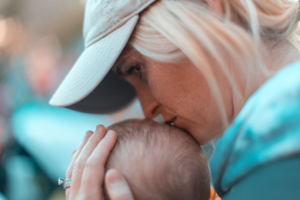 a mother kissing her baby's head