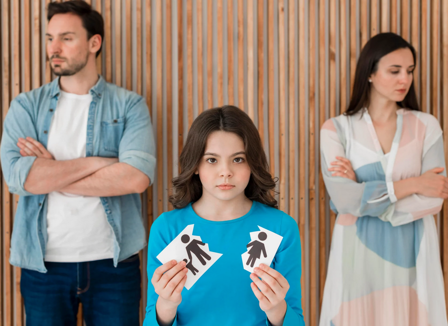 A child holding a ripped paper depicting parents' separation and child custody issues