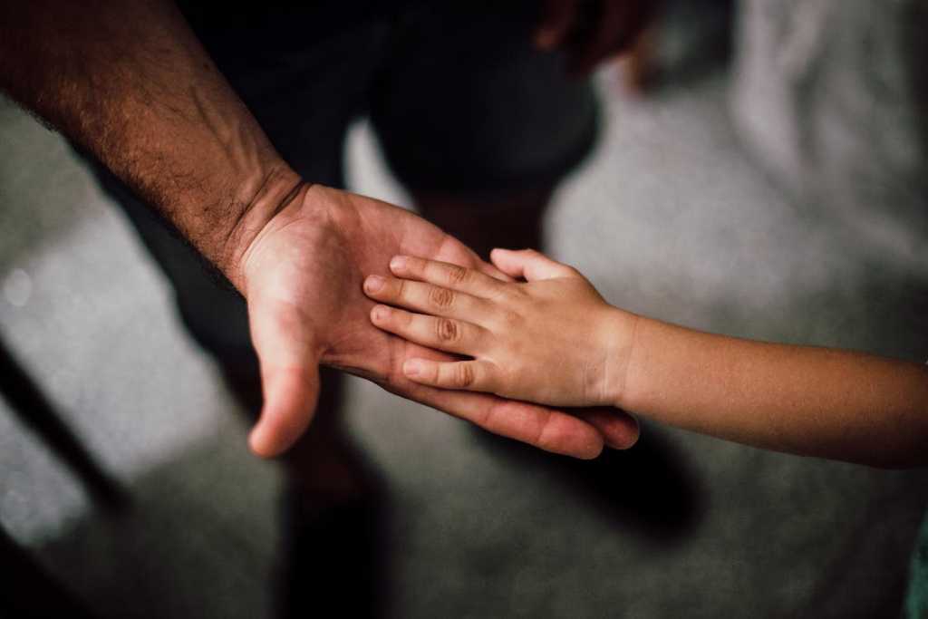 A child’s hand on an adult’s hand