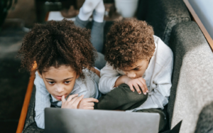 Two kids looking at a laptop