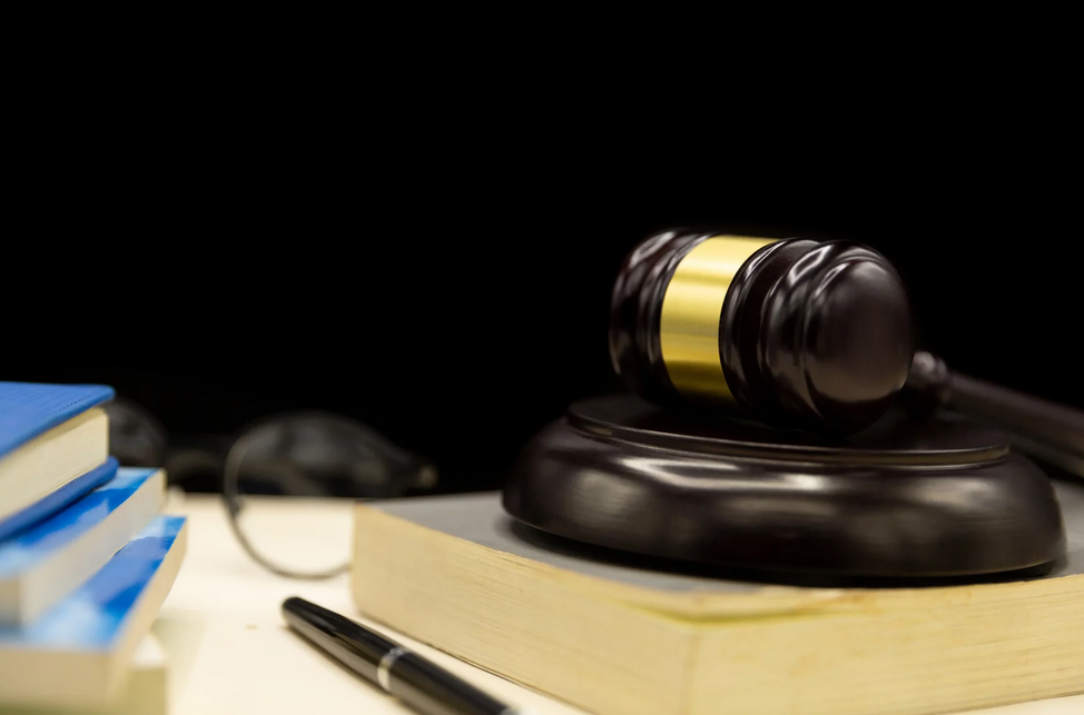 A wooden gavel on top of a book