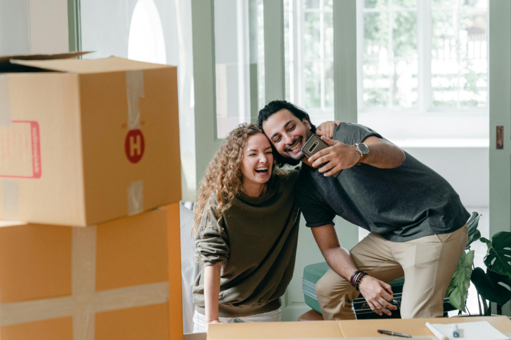 A couple having just moved into a new house is taking a selfie