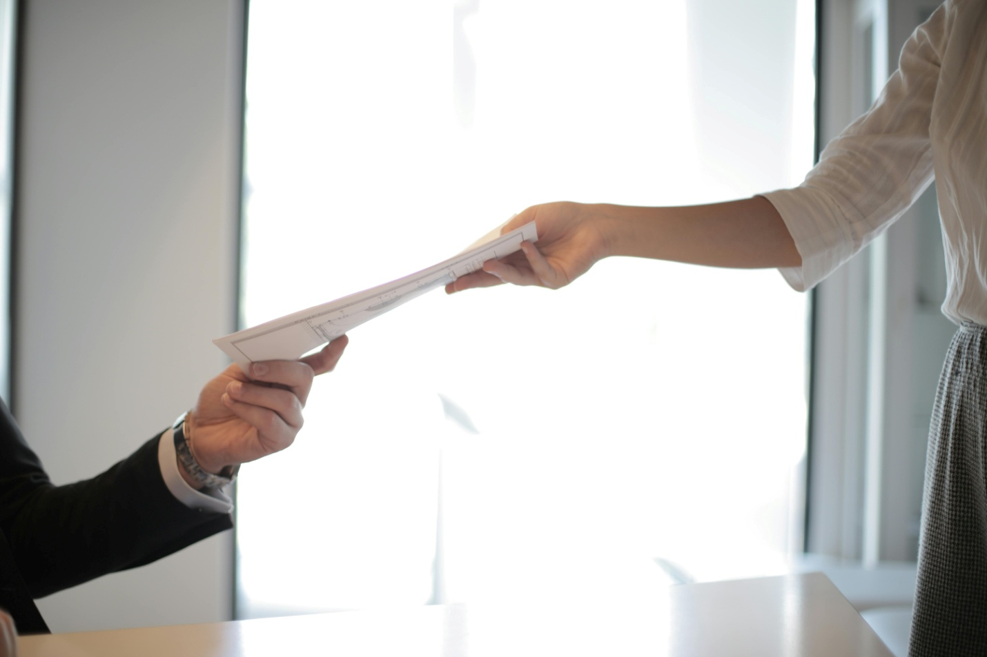 A woman handing over documents to her personal injury lawyer