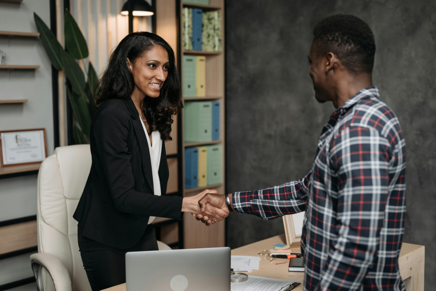 A lawyer and her client are shaking hands with each other