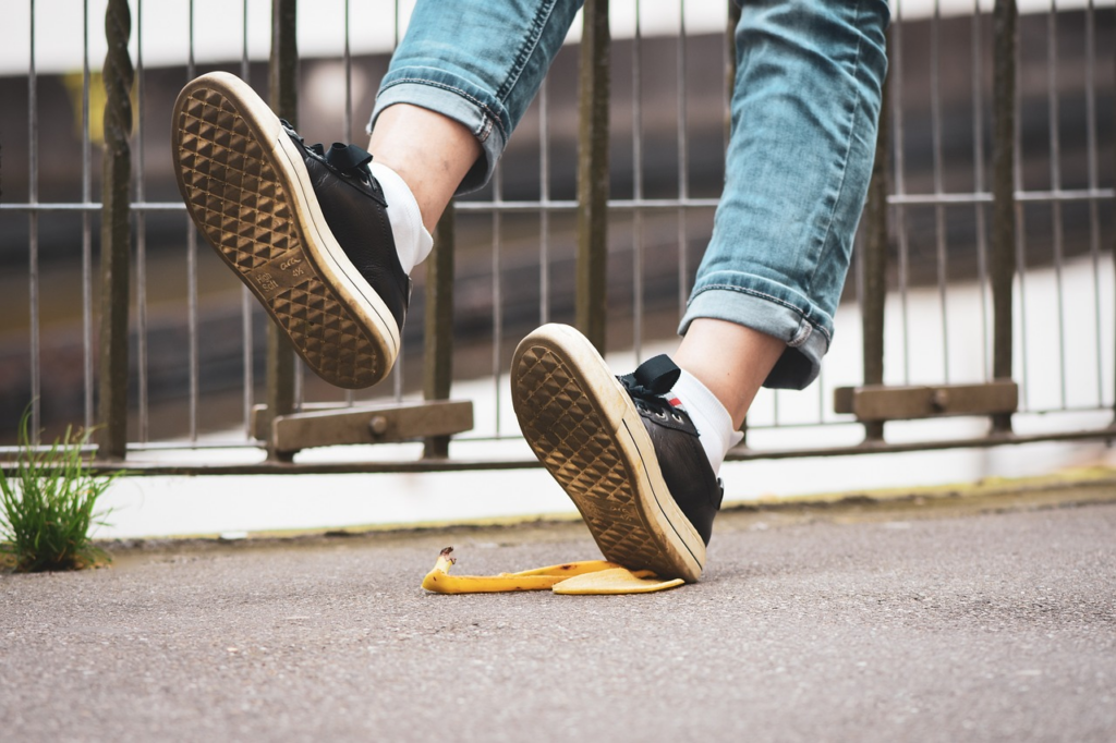 A person slipping having stepped onto a banana peel