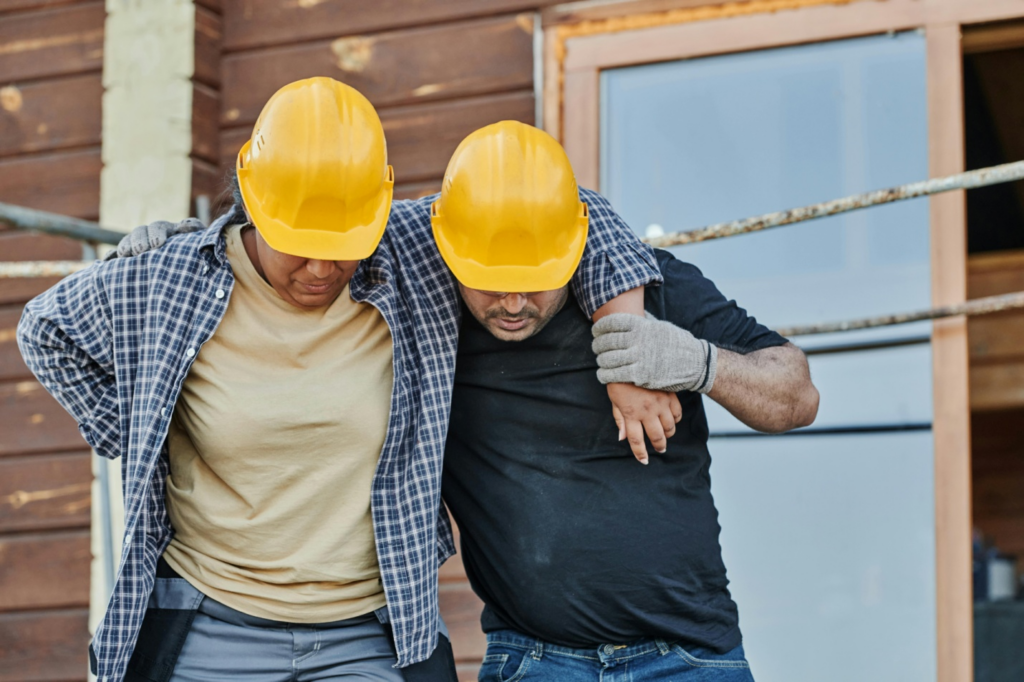 A man helping an injured fellow-worker