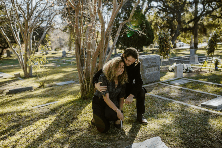 A woman crying in a graveyard while a man tries to comfort her