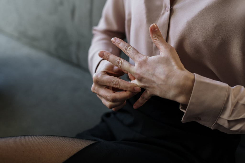 Person taking off their wedding ring by https://www.pexels.com/photo/person-in-white-long-sleeve-shirt-and-black-pants-4098230/