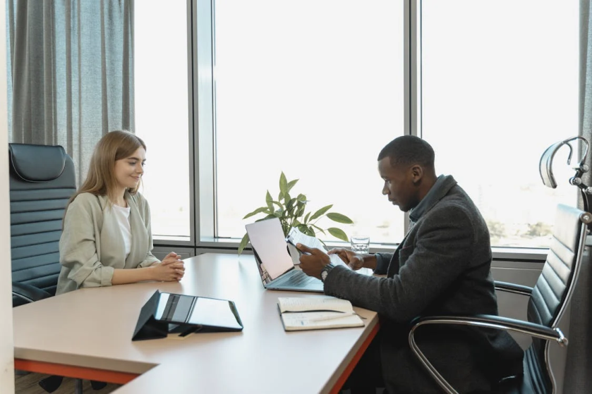 An image of a man and woman sitting at a table and looking at a document