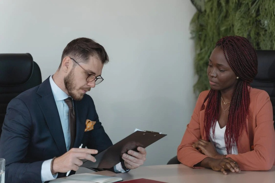 An image of a man and woman sitting at a table and looking at a document