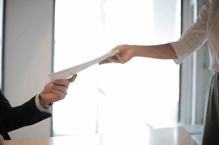 A child support lawyer in Austin handing paperwork to a client