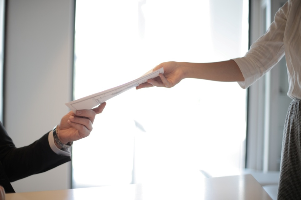 A child support lawyer in Austin handing paperwork to a client