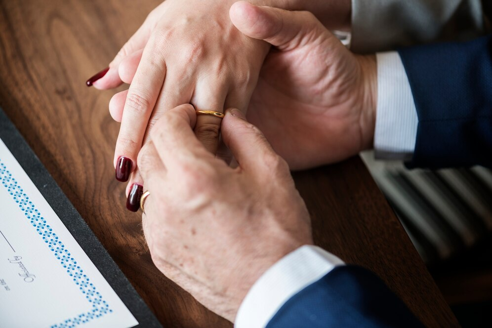 A man putting a ring on a woman's finger
