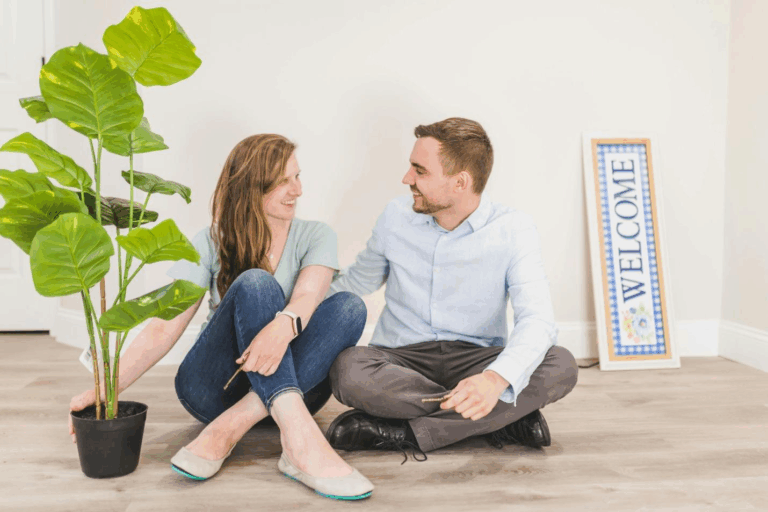 A picture of a couple sitting on the floor of a new house