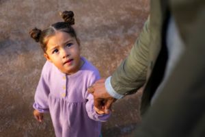 A girl looking up at her mother during court-ordered visitation