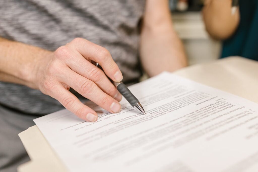 A cropped image of a person signing an uncontested divorce agreement