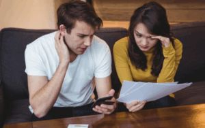Couple sitting on a sofa and reviewing financial documents together