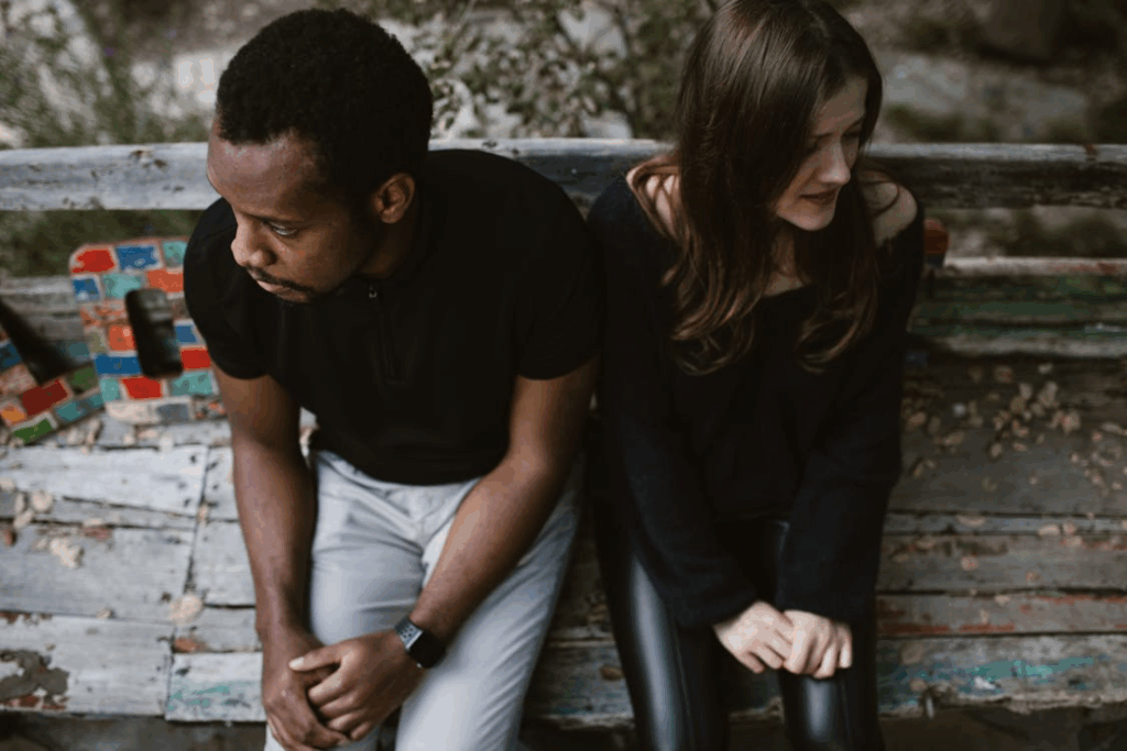 A couple sitting on a bench looking in opposite directions, symbolizing emotional separation before divorce