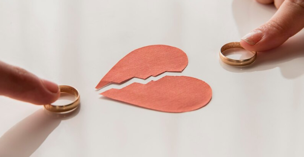 Two hands gently touching wedding rings