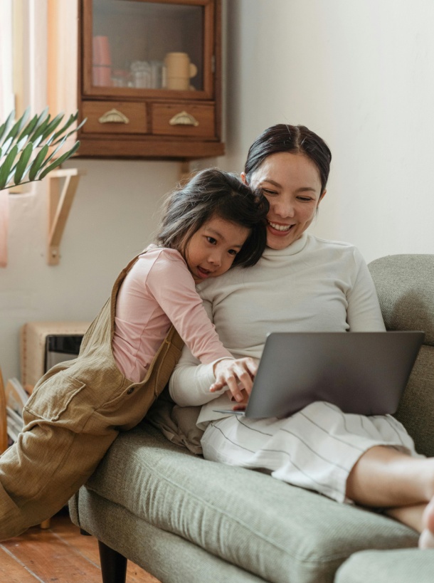 A mother and her daughter looking at a laptop