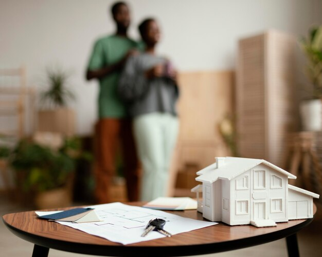 A miniature house and keys on a table