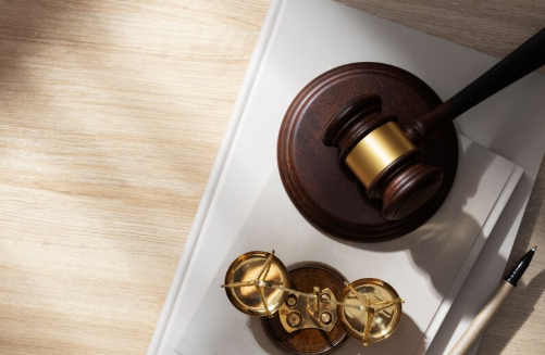 Top-down view of legal items including gavel, legal books, and paperwork on judge’s desk
