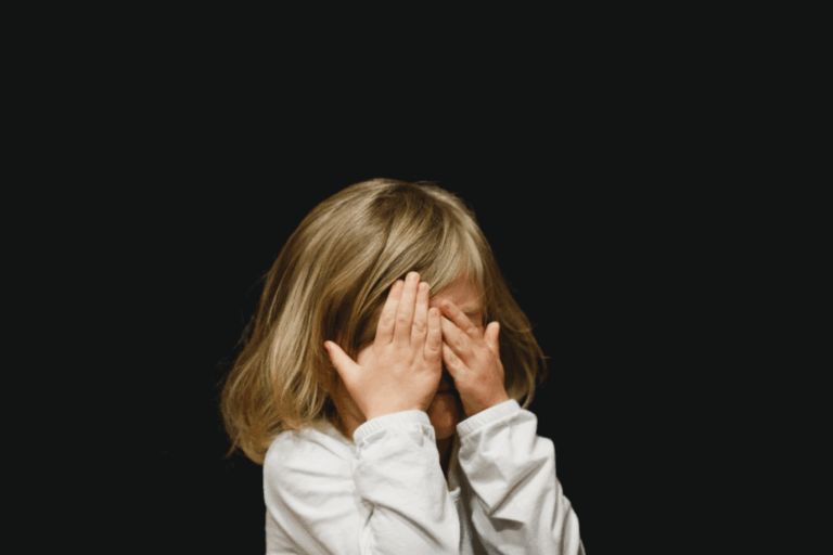 A child covering her face