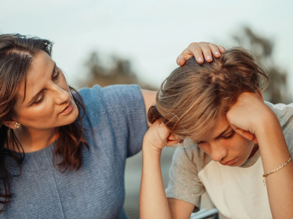 A mother with her hand on her son's head