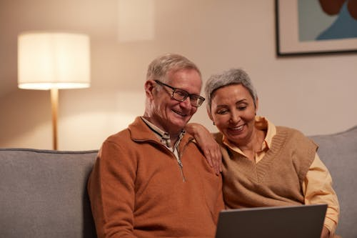 An old couple looking at a laptop