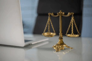  a golden balance on a lawyer's desk with a laptop
