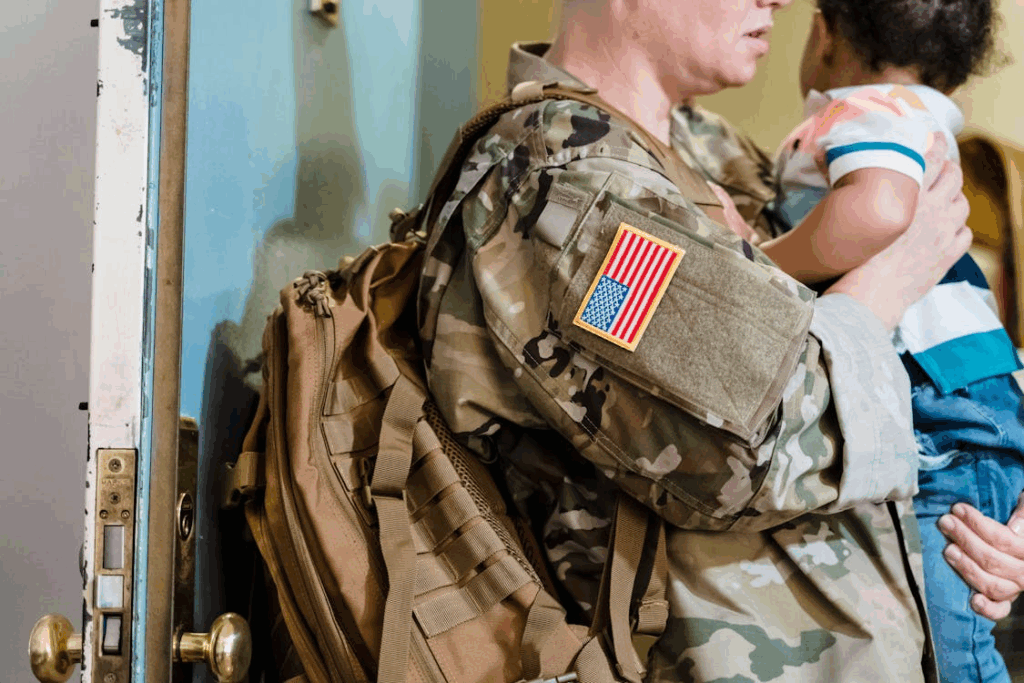 a woman in a military uniform holding a baby in her arms