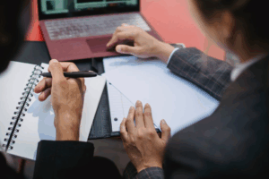 Two Houston property division lawyers review documents and notes during a client consultation.