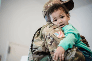 a baby crying on their military fathers shoulder