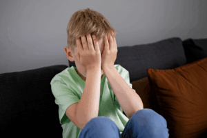 a child covering his face and crying