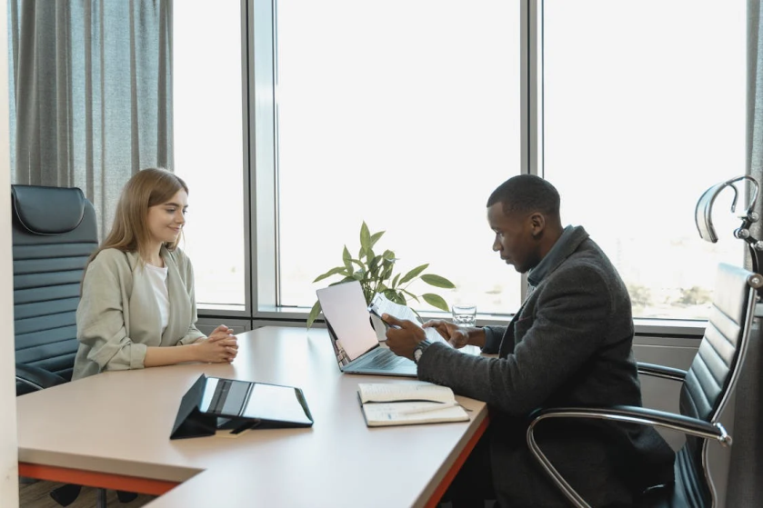 An image of a man and woman sitting at a table and looking at a document