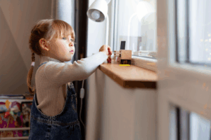 a kid looking out the window from their playroom