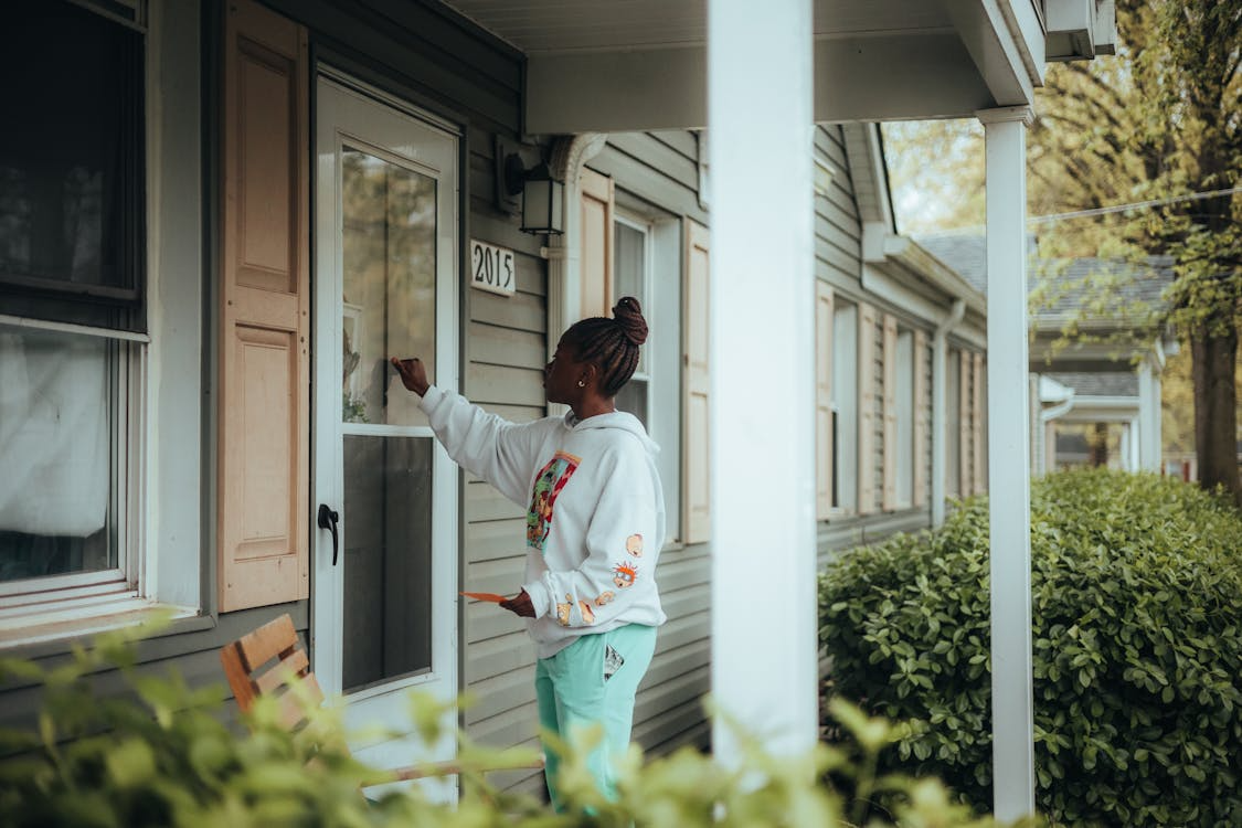a woman knocking on a house door