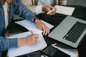 Two individuals reviewing financial charts and forms with help from a Houston property division lawyer.