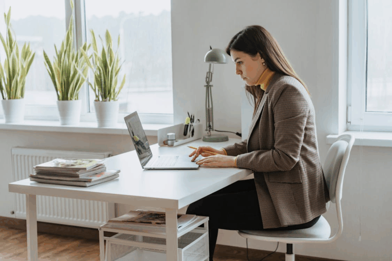 A professional woman focuses on legal documents on her laptop, representing a family lawyer in Houston assisting with client cases.